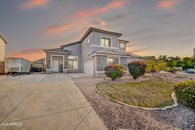 view of front facade featuring a tiled roof, concrete driveway, and stone siding