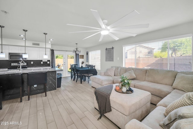 living room featuring french doors, a ceiling fan, recessed lighting, light wood-type flooring, and visible vents