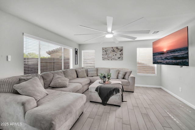 living area with baseboards, a ceiling fan, light wood-type flooring, and visible vents