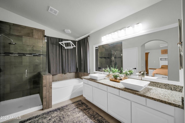 ensuite bathroom with double vanity, visible vents, a stall shower, a sink, and lofted ceiling