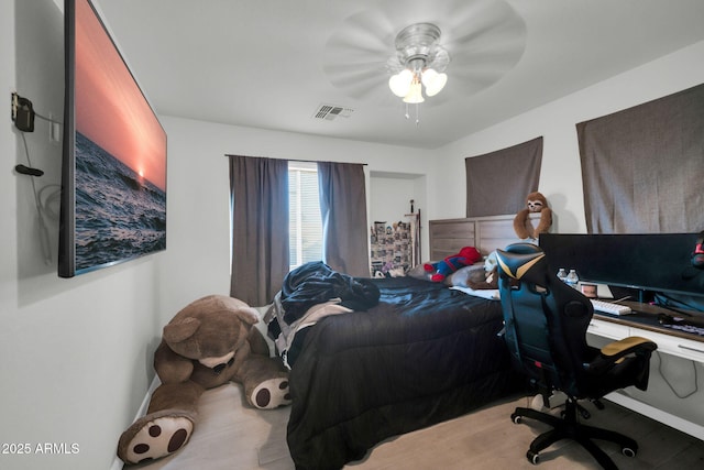 bedroom with ceiling fan, wood finished floors, and visible vents