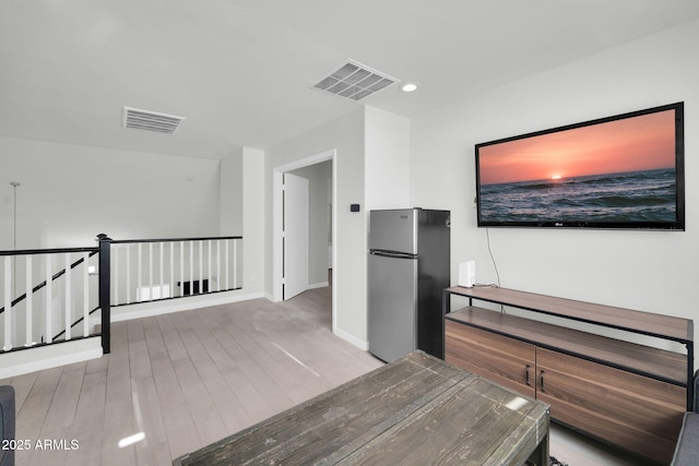 interior space featuring an upstairs landing, recessed lighting, wood finished floors, and visible vents