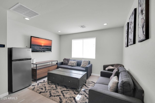 living room with baseboards, recessed lighting, light wood-style flooring, and visible vents