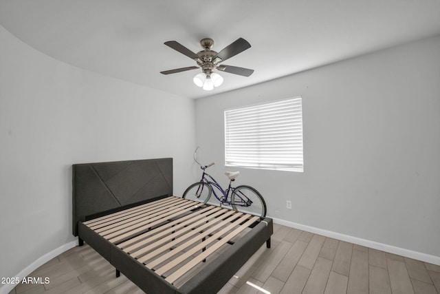 bedroom featuring baseboards, a ceiling fan, and wood finished floors