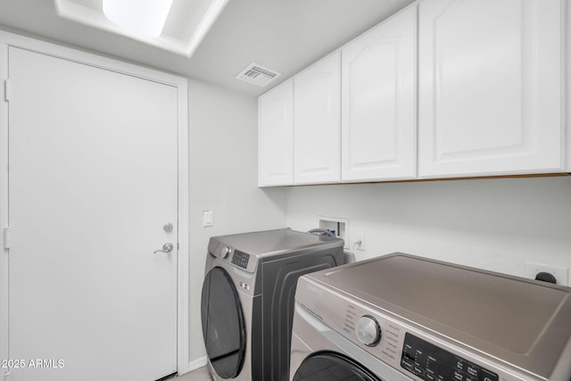 laundry area featuring cabinet space, separate washer and dryer, and visible vents