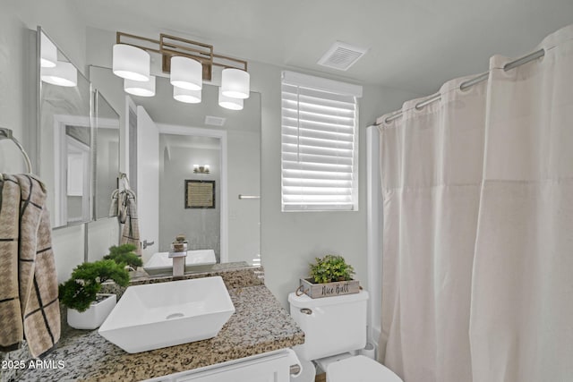 bathroom featuring toilet, visible vents, and vanity