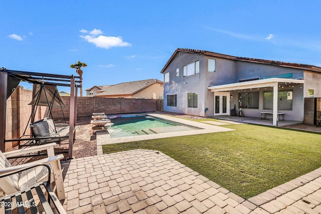 rear view of property featuring french doors, a patio area, a fenced in pool, a fenced backyard, and stucco siding