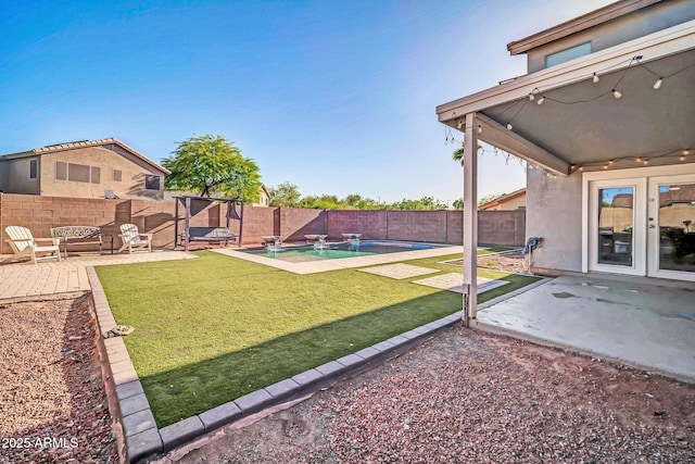 view of yard featuring a patio, a fenced in pool, and a fenced backyard