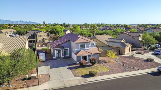 view of front of house with a residential view, stucco siding, concrete driveway, and a tile roof