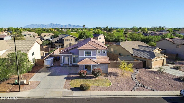 view of front of house featuring fence, stucco siding, a tiled roof, driveway, and a residential view