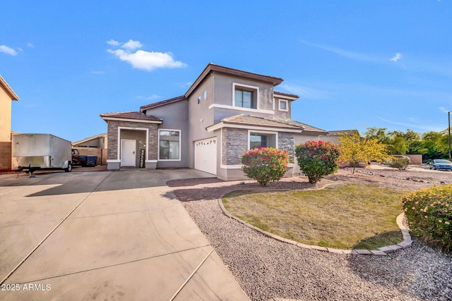 view of front of home with driveway, a tile roof, stone siding, and stucco siding