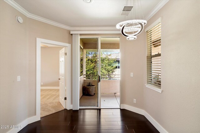 interior space with baseboards, a notable chandelier, crown molding, and dark wood-style flooring