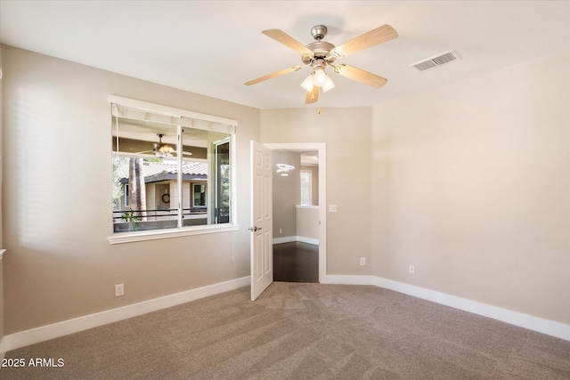 empty room featuring baseboards, carpet flooring, visible vents, and a ceiling fan