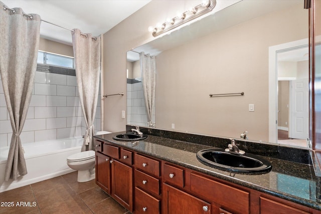bathroom featuring tile patterned floors, toilet, double vanity, and a sink
