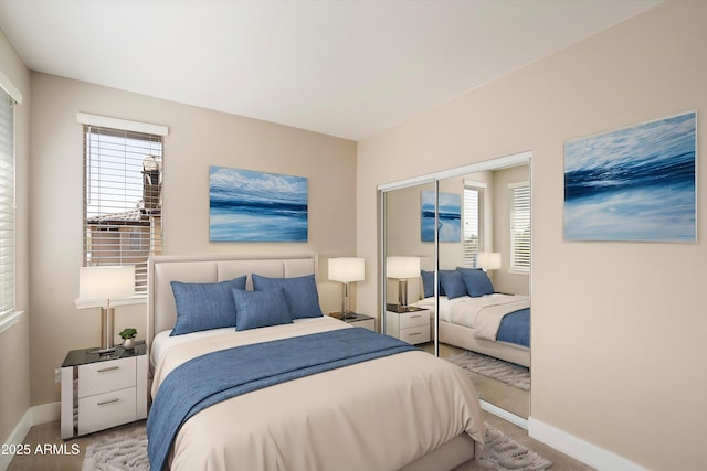 bedroom with carpet flooring, baseboards, and a closet