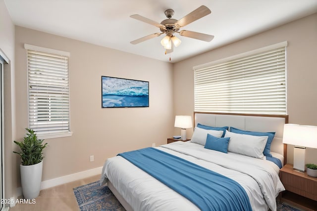 carpeted bedroom featuring baseboards and a ceiling fan