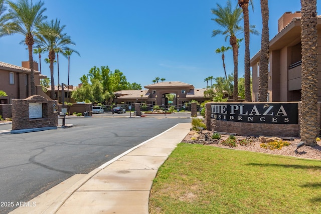 view of street featuring sidewalks, a gated entry, and curbs