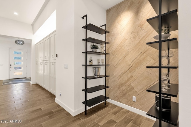 interior space with wood tiled floor, an accent wall, and baseboards