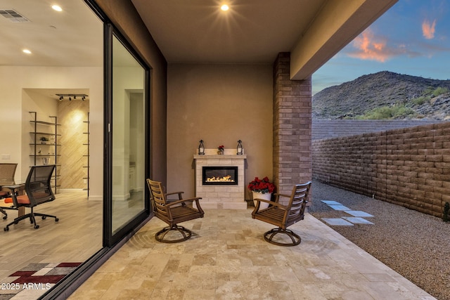 view of patio featuring visible vents, a fireplace, and a mountain view