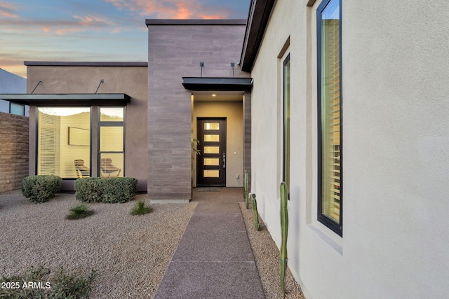 doorway to property featuring stucco siding