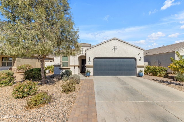 mediterranean / spanish home with driveway, an attached garage, a tiled roof, and stucco siding