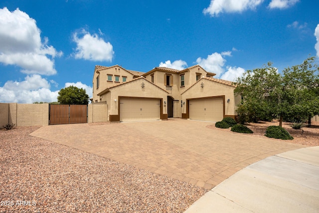 7432 W Bronco Trl, Peoria, AZ 85383 - mediterranean / spanish-style home with a gate, a garage, decorative driveway, stucco siding, and a tile roof