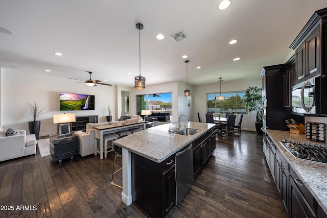 7432 W Bronco Trl, Peoria, AZ 85383 - kitchen featuring appliances with stainless steel finishes, a sink, dark wood finished floors, recessed lighting, and a breakfast bar