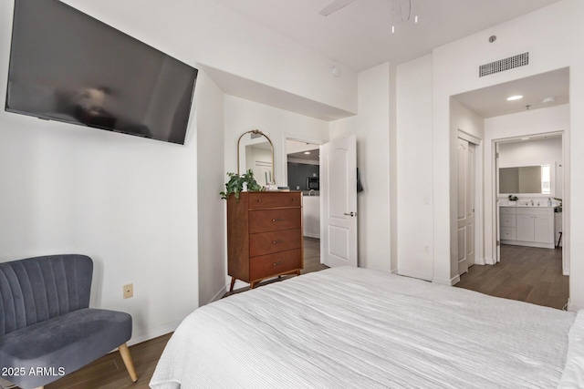 bedroom with ensuite bathroom, a closet, ceiling fan, and dark wood-type flooring