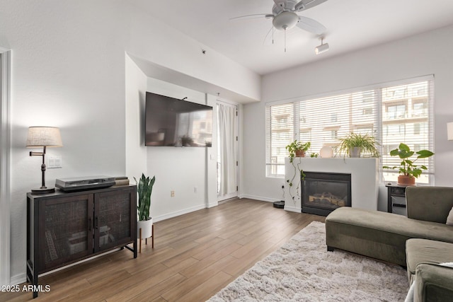 living room featuring hardwood / wood-style floors, plenty of natural light, and ceiling fan