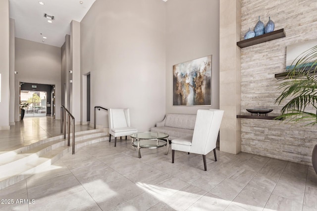 interior space featuring a towering ceiling and light tile patterned floors