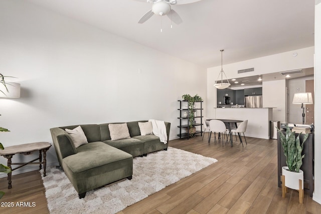 living room with ceiling fan and dark wood-type flooring