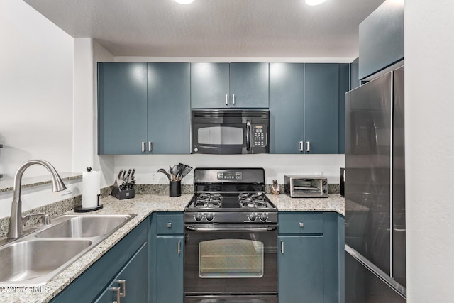 kitchen featuring black appliances, sink, blue cabinetry, and a textured ceiling