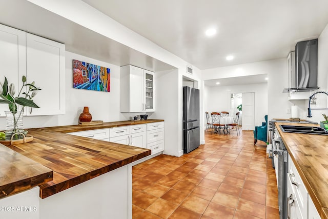 1451 E Brown Rd, Mesa, AZ 85203 - kitchen with freestanding refrigerator, glass insert cabinets, butcher block countertops, recessed lighting, and white cabinetry