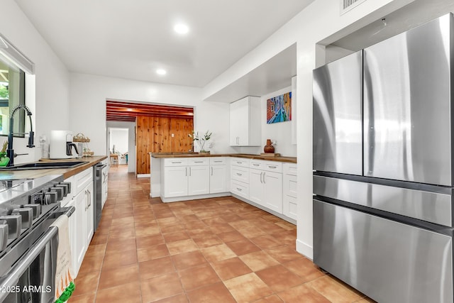 1451 E Brown Rd, Mesa, AZ 85203 - kitchen with wooden counters, recessed lighting, white cabinets, a sink, and stainless steel appliances