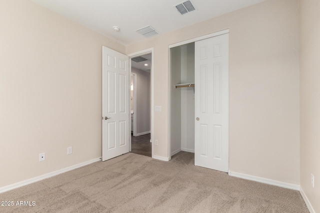 unfurnished bedroom featuring light carpet and a closet