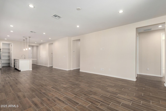 unfurnished living room featuring sink