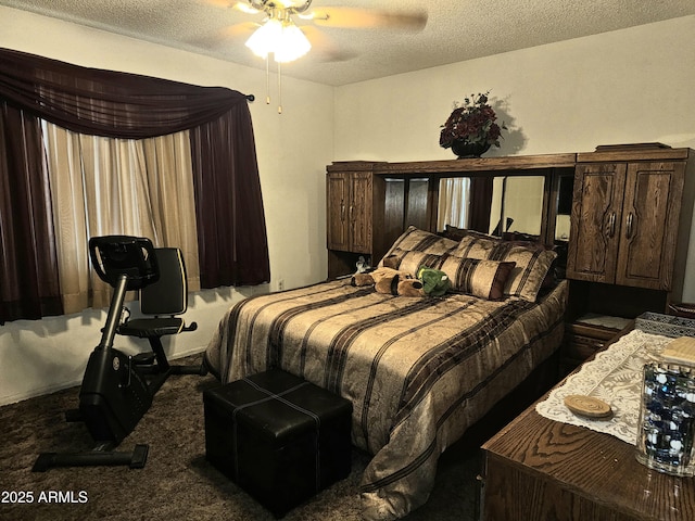 bedroom featuring ceiling fan, dark carpet, and a textured ceiling