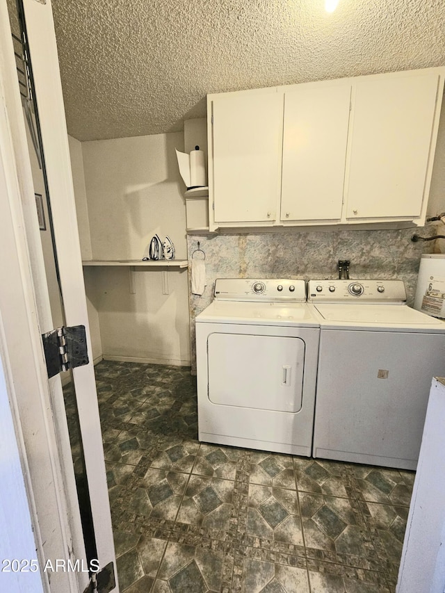 washroom featuring cabinets, separate washer and dryer, and a textured ceiling