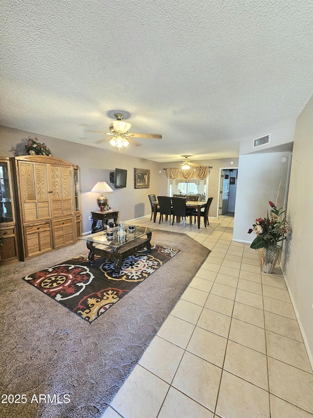 tiled living room with ceiling fan and a textured ceiling