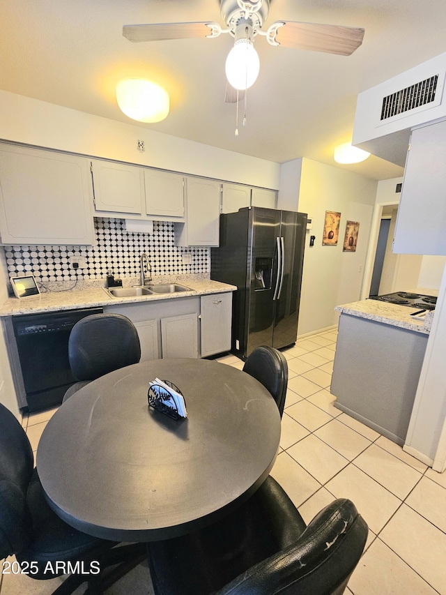 tiled dining room featuring ceiling fan and sink