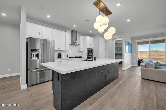 31435 N 130th Ave, Peoria, AZ 85383 - kitchen with a large island with sink, stainless steel fridge with ice dispenser, wall chimney range hood, baseboards, and light wood-style flooring