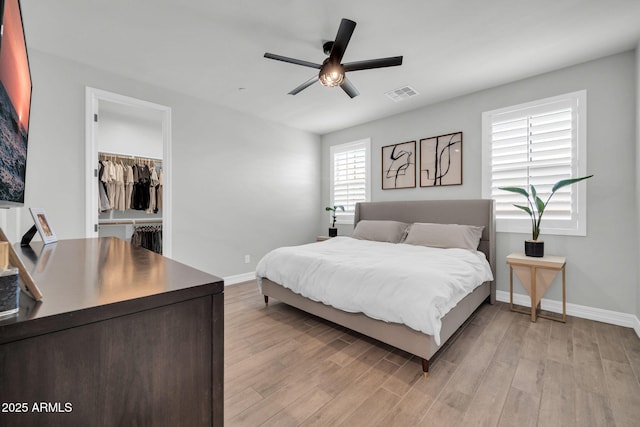 31435 N 130th Ave, Peoria, AZ 85383 - bedroom with a walk in closet, light wood-style floors, visible vents, and baseboards