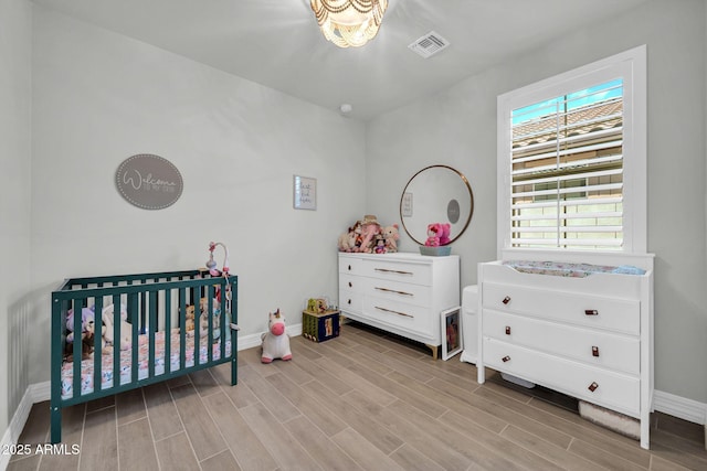 31435 N 130th Ave, Peoria, AZ 85383 - bedroom with baseboards, wood finished floors, visible vents, and a crib