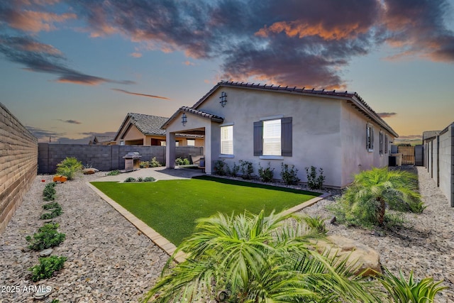 31435 N 130th Ave, Peoria, AZ 85383 - back of house featuring a tiled roof, a fenced backyard, a yard, a patio, and stucco siding