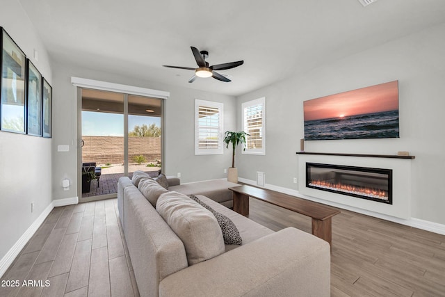 31435 N 130th Ave, Peoria, AZ 85383 - living room featuring baseboards, a ceiling fan, wood finished floors, and a glass covered fireplace