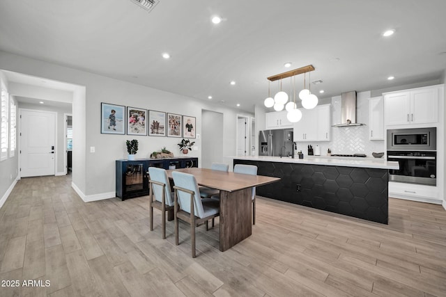 31435 N 130th Ave, Peoria, AZ 85383 - kitchen featuring wall chimney range hood, light wood-style flooring, stainless steel appliances, and recessed lighting