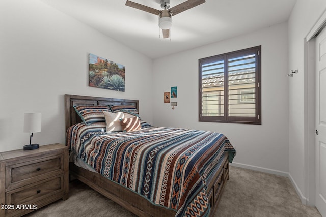 bedroom featuring light colored carpet, ceiling fan, and a closet