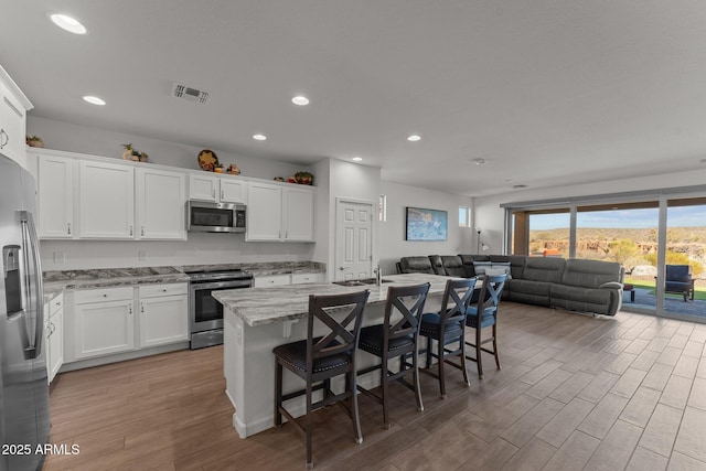 kitchen featuring white cabinetry, an island with sink, and appliances with stainless steel finishes