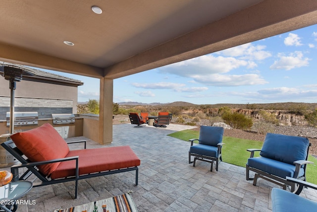 view of patio featuring exterior kitchen, grilling area, and a mountain view