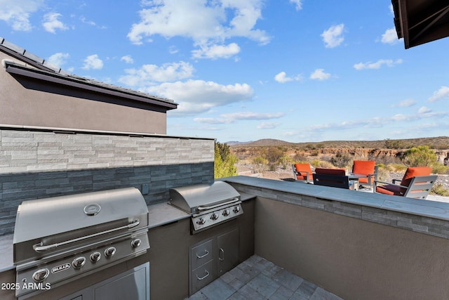 view of patio / terrace with an outdoor kitchen, grilling area, and a mountain view